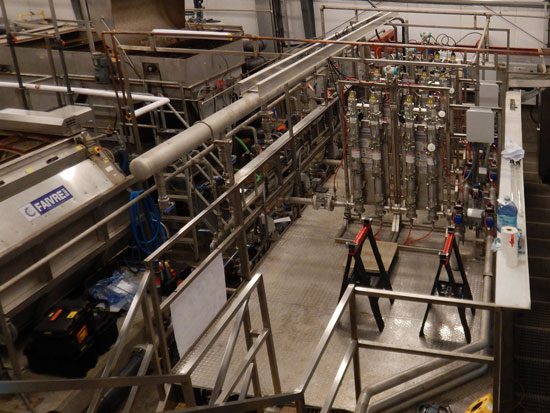 Industrial stainless steel piping system in a manufacturing facility.