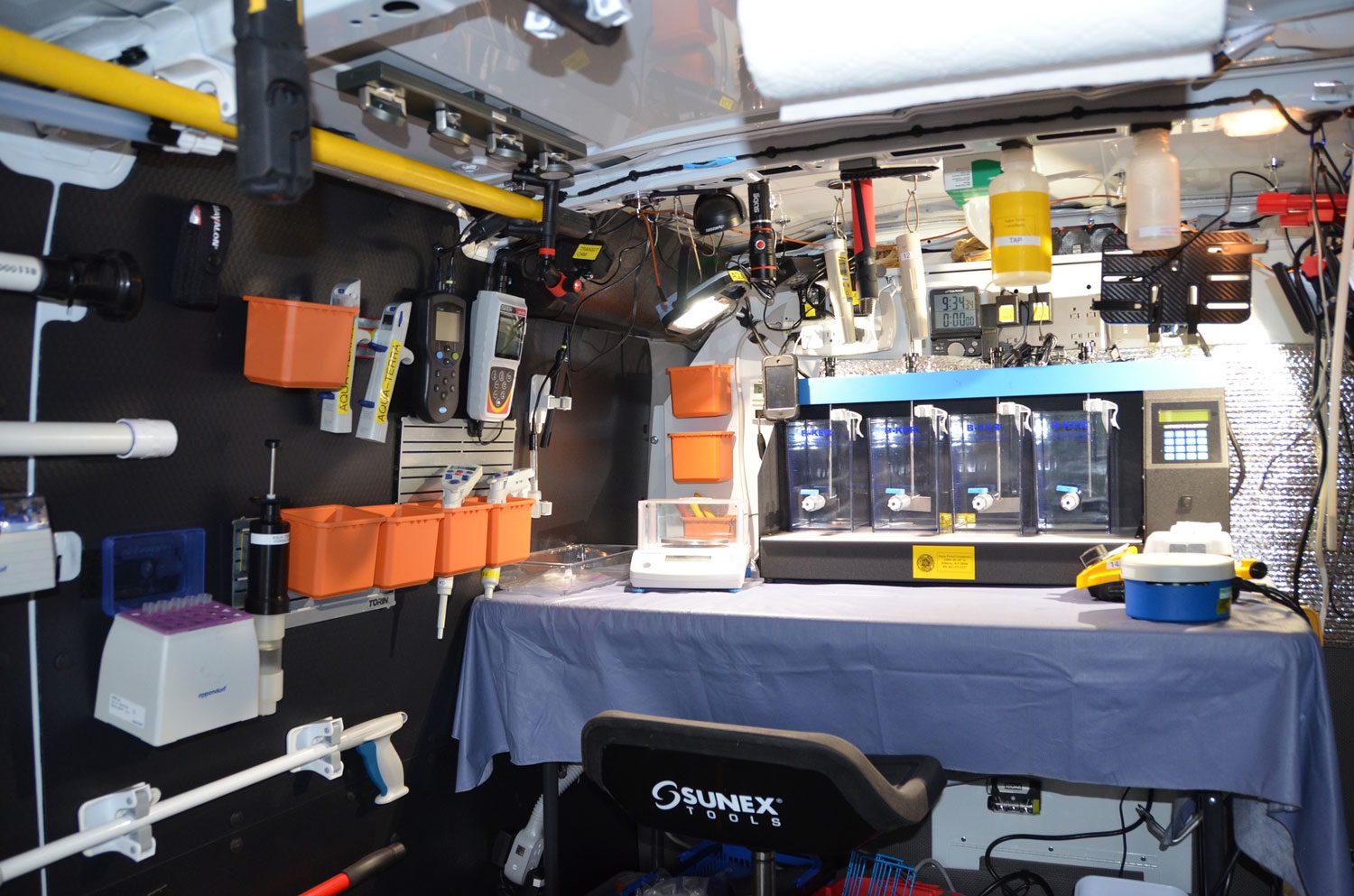 Inside a well-equipped underwater research submersible cabin with control panels and instruments.
